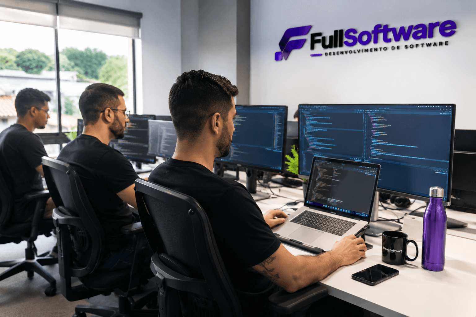 Equipe trabalhando em computadores durante o desenvolvimento de um projeto